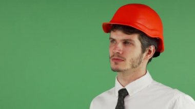 Yakışıklı erkek constructionist uzakta düşünceli arıyorum bir kask içinde