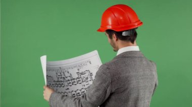 Taslakları incelenirken kameraya gülümseyen yakışıklı sakallı mühendisi