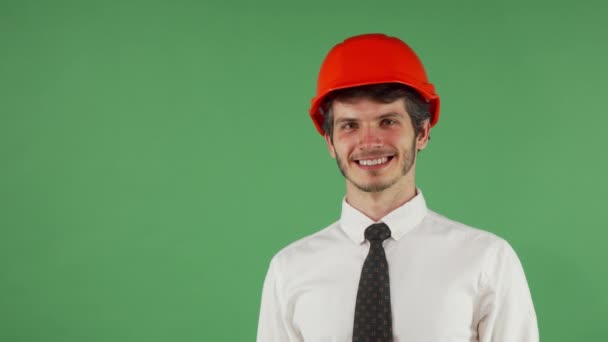 Fröhlich gut aussehende männliche Ingenieur trägt Hardhat zwinkert in die Kamera — Stockvideo