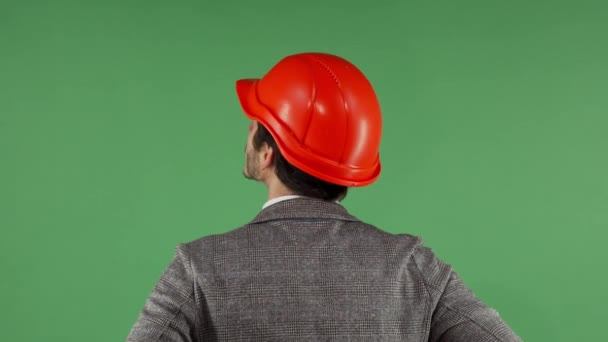 Rückseite Porträt eines Bauunternehmers mit Bollenhut, der auf den grünen Bildschirm blickt — Stockvideo
