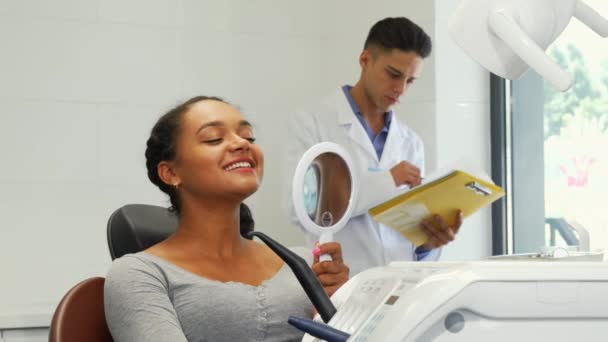 Preciosa mujer africana mirando su sonrisa sana perfecta en el espejo — Vídeos de Stock