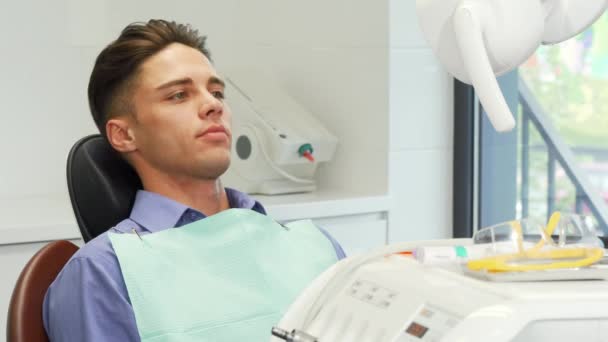 Paciente masculino con gafas protectoras con pulgares en el consultorio del dentista — Vídeos de Stock