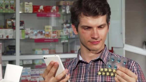 Молодой человек покупает лекарства в аптеке — стоковое видео
