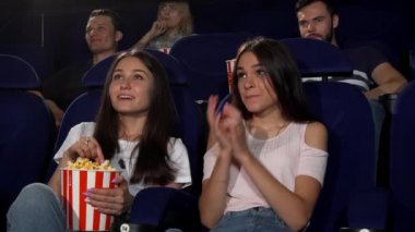 Güzel genç kadın sinemada film izlerken zevk