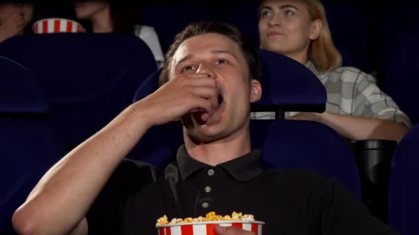 Feliz hombre atractivo sonriendo a la cámara en el cine — Vídeos de Stock