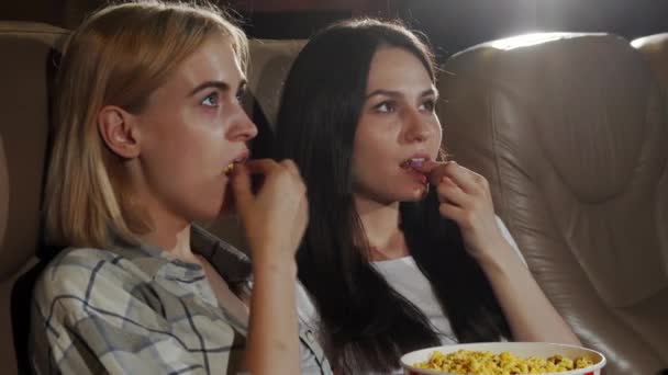 Belle donne che mostrano pollici in su mentre guardano il film al cinema — Video Stock