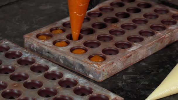 Chocolatier preparación hecha a mano crema llena de chocolate caramelo — Vídeos de Stock