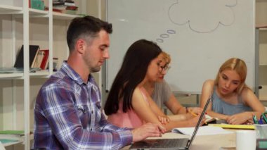 Yakışıklı erkek öğrenci dizüstü bilgisayar kullanırken başparmak gösterilmesini