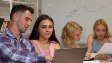 İki genç neşeli öğrenciler dizüstü bilgisayarda kendi proje tartışıyor