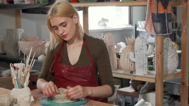 Чудова молода жінка посміхається під час роботи з глиною на майстерні — стокове відео