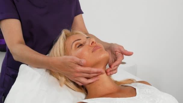 Mulher madura sorrindo durante a massagem facial no salão de beleza — Vídeo de Stock