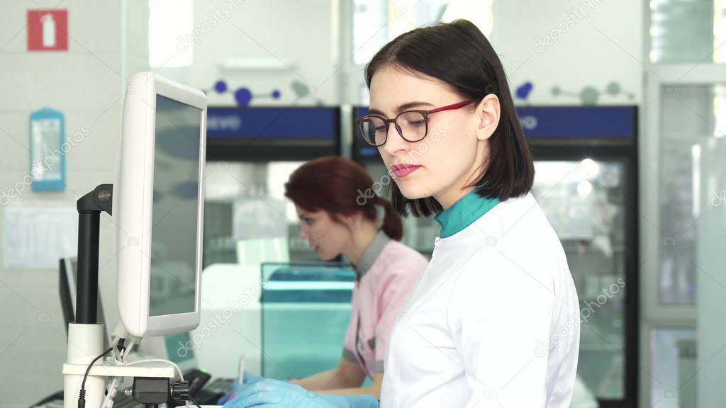 Beautiful female scientist working on a computer at the lab