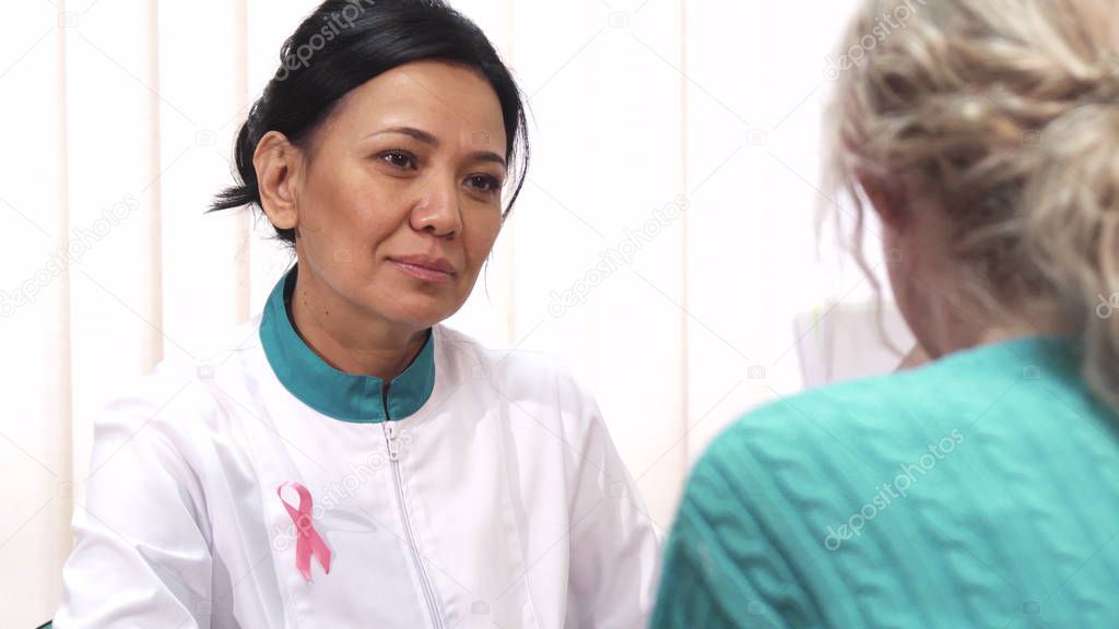 Beautiful mature female doctor talking to her patient