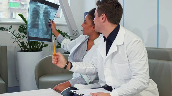 Médico do sexo masculino aponta para o raio-X no hospital — Fotografia de Stock