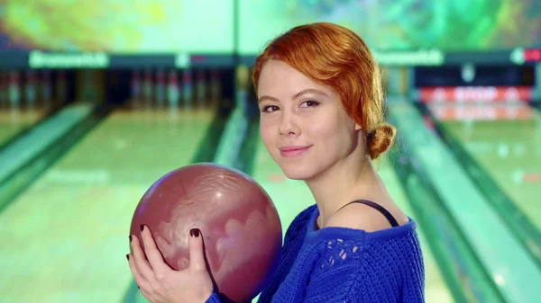 Girl smiling with bowling ball in her hands — Stock Photo, Image