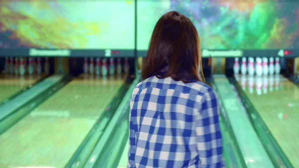 Girl knocks down pins at the bowling — Stock Photo, Image