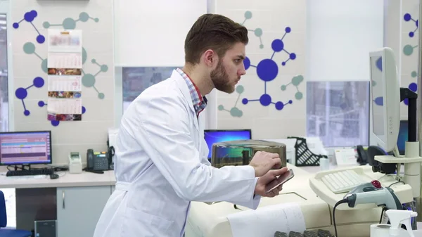 L'homme entre les informations de l'ordinateur à la tablette au laboratoire — Photo