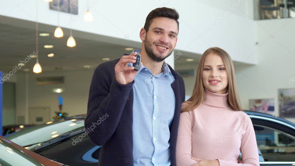 Man shows the car key at the dealership