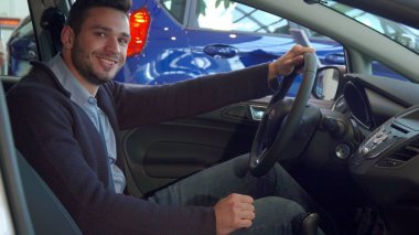 Adam onun emniyet kemeri arabada takılır.