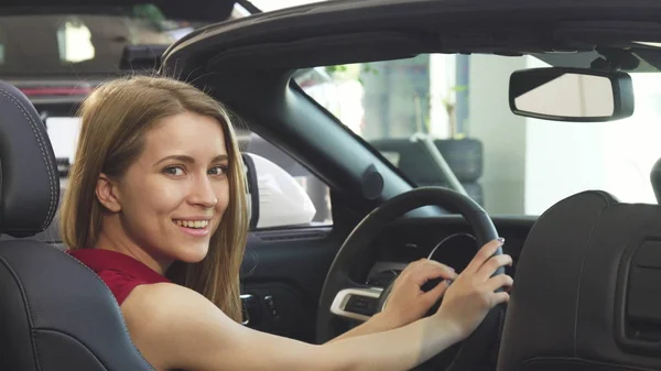 Umwerfende junge Fahrerin lächelt freudig in ihrem Cabrio — Stockfoto