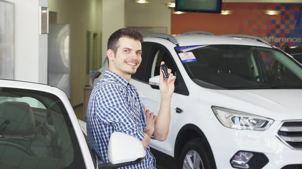 Glücklicher junger gutaussehender Mann posiert mit seinem neuen Auto und zeigt Schlüssel — Stockfoto