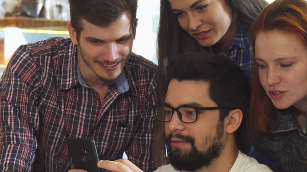 Groep vrienden met behulp van slimme telefoon samen bij de koffieshop — Stockfoto
