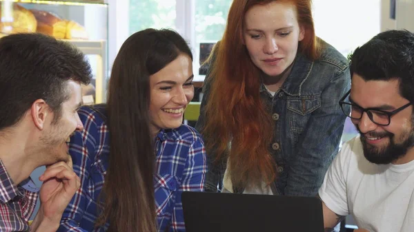 Group of friends laughing while using laptop together — Stock Photo, Image