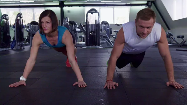 Fitness homem e mulher fazer flexões no ginásio — Fotografia de Stock