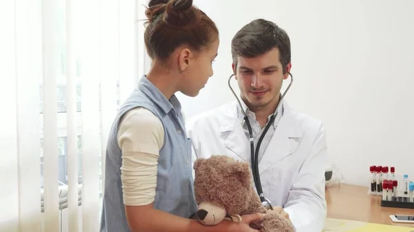 El buen doctor está escuchando a través del juguete suave de una chica estetoscopio — Foto de Stock