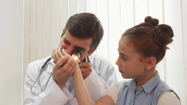 Seorang gadis kecil yang baik duduk diam sementara dokter memeriksa dirinya — Stok Foto