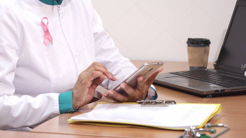 Cropped shot of a female therapist using smart phone at work