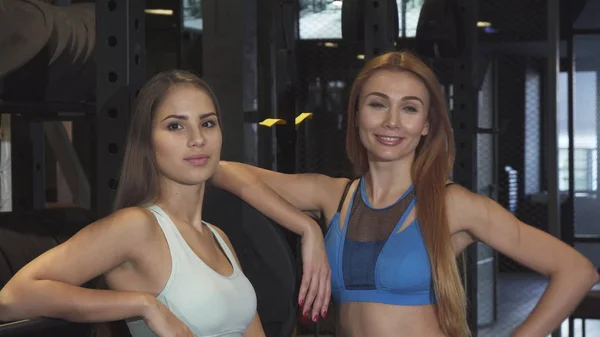 Dos hermosas mujeres de fitness sonriendo a la cámara en el estudio de deportes — Foto de Stock