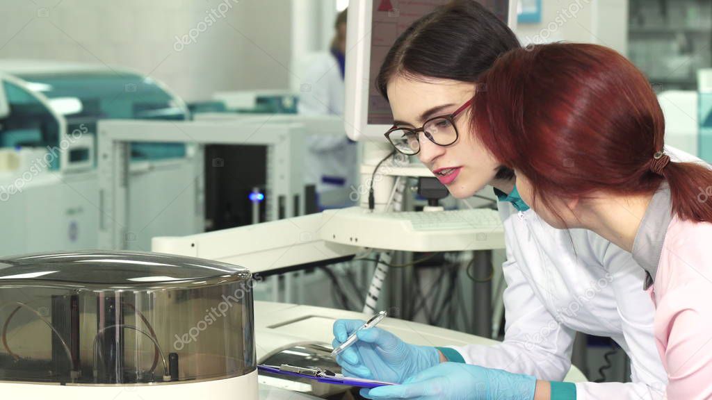 Two female biologists making notes while conducting experiments