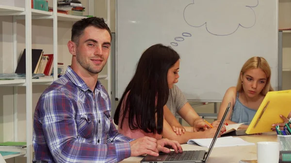 Knappe mannelijke student tonen duimen omhoog terwijl het gebruiken van laptop — Stockfoto