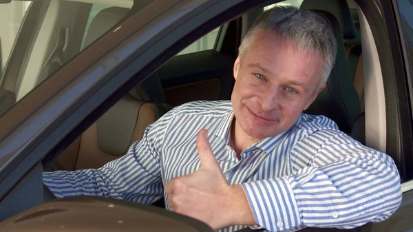 Mature man sits into the car at the dealership