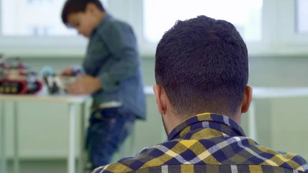 Man horloges dat zijn zoon speelt met speelgoed — Stockfoto