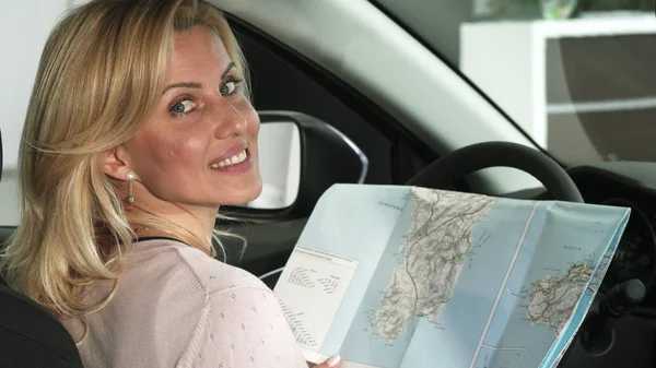 Nahaufnahme einer Autofahrerin mit einer Landkarte in ihrem Auto — Stockfoto