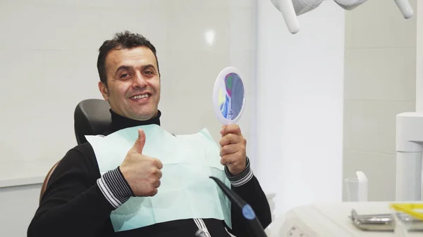 快乐成熟男子在牙科检查后显示大拇指 — 图库照片