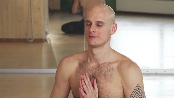 Close up of a handsome young man meditating in yoga position — Stock Photo, Image