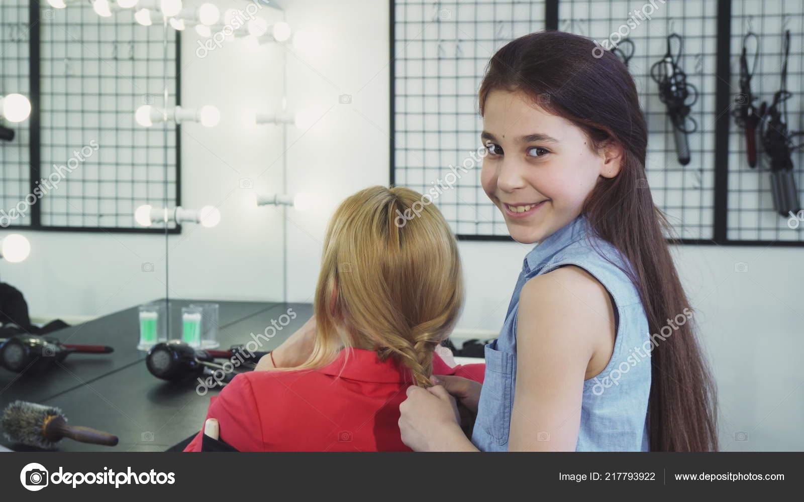 Cute Cheerful Little Girl Braiding Hair Of Her Mom Smiling To The