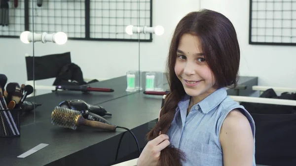 Carino ragazza felice intrecciare i capelli sorridendo alla fotocamera — Foto Stock