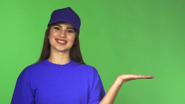 Hermosa trabajadora en una gorra de béisbol y camiseta presentando espacio de copia — Foto de Stock