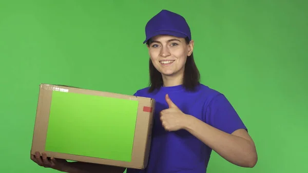 Atractiva joven partera mostrando los pulgares hacia arriba sosteniendo la caja de cartón —  Fotos de Stock