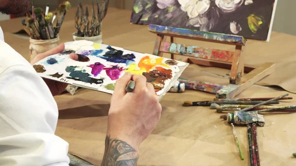Close up tiro de um pintor espremendo tinta a óleo em sua paleta — Fotografia de Stock
