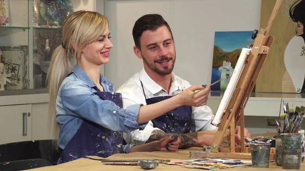 Milující se mladý pár těší pracovat na malířství v ateliéru společně — Stock fotografie