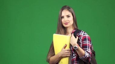 Genç güzel kız öğrenci kameraya gülümseyen bir sırt çantası ile