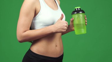 Su şişesi tutarak yukarı başparmak gösterilen bir sporcumuz kırpılmış görüntüsünü kapatmak