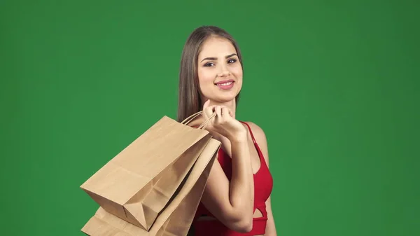 Joven hermosa mujer feliz sonriendo sosteniendo bolsas de compras en chromakey — Foto de Stock