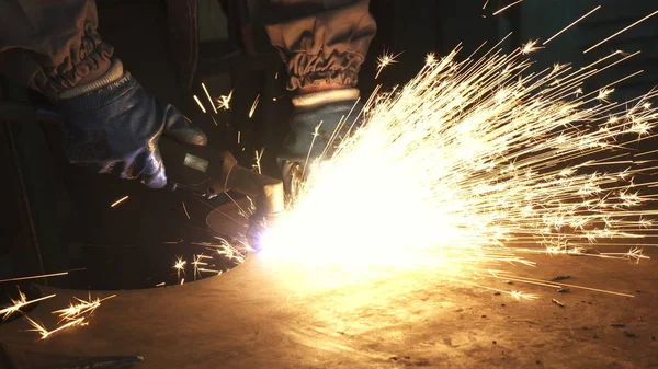 Recortado tiro de un trabajador de la fábrica de corte de acero con chispas que vuelan alrededor — Foto de Stock