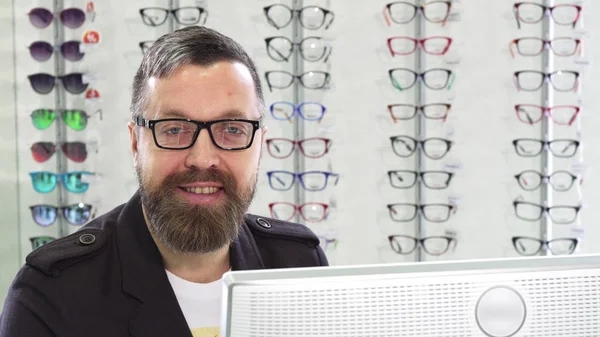 Mogen optiker arbetar med en dator på sin butik — Stockfoto